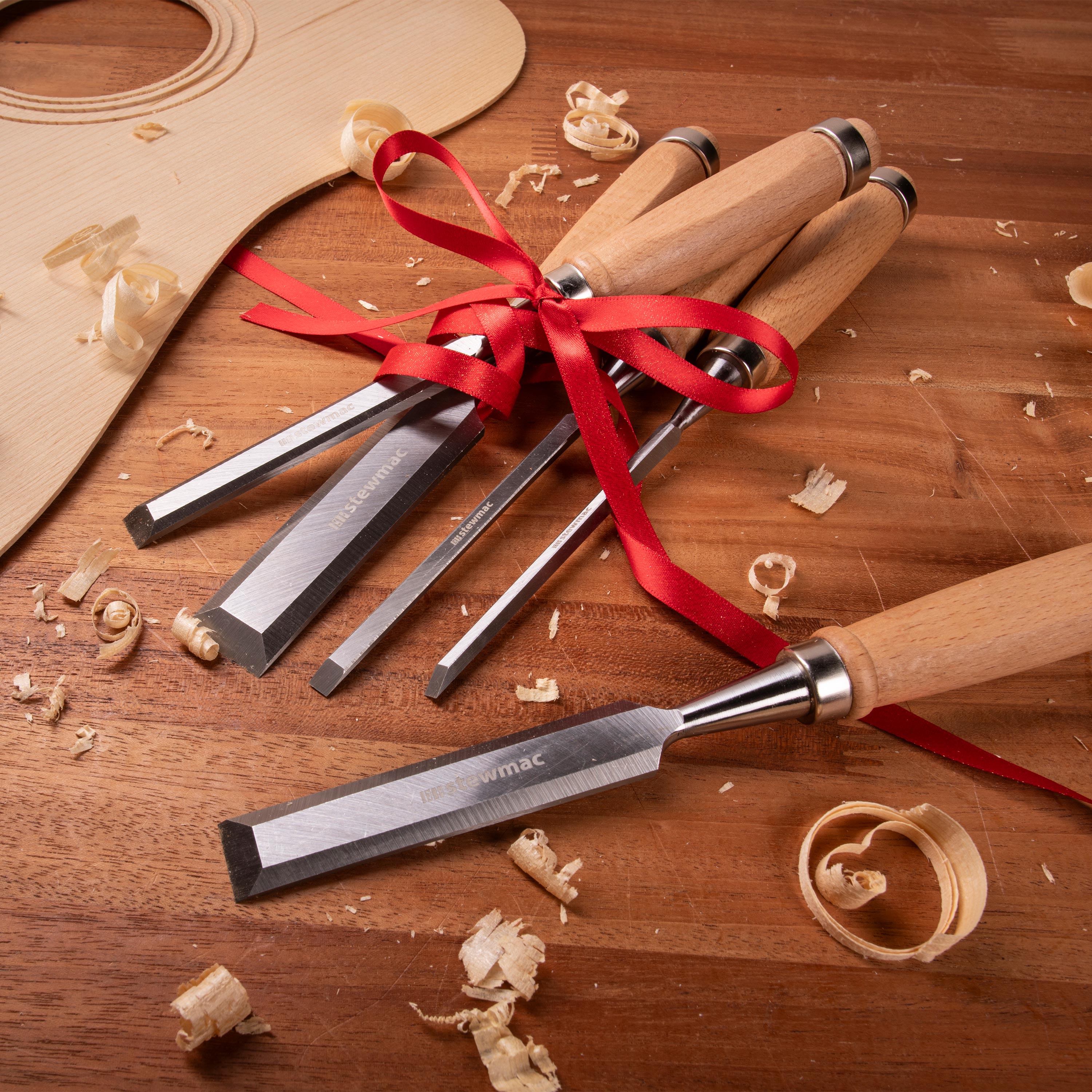 Juego de cinceles de madera en un banco de trabajo con cinta de regalo.