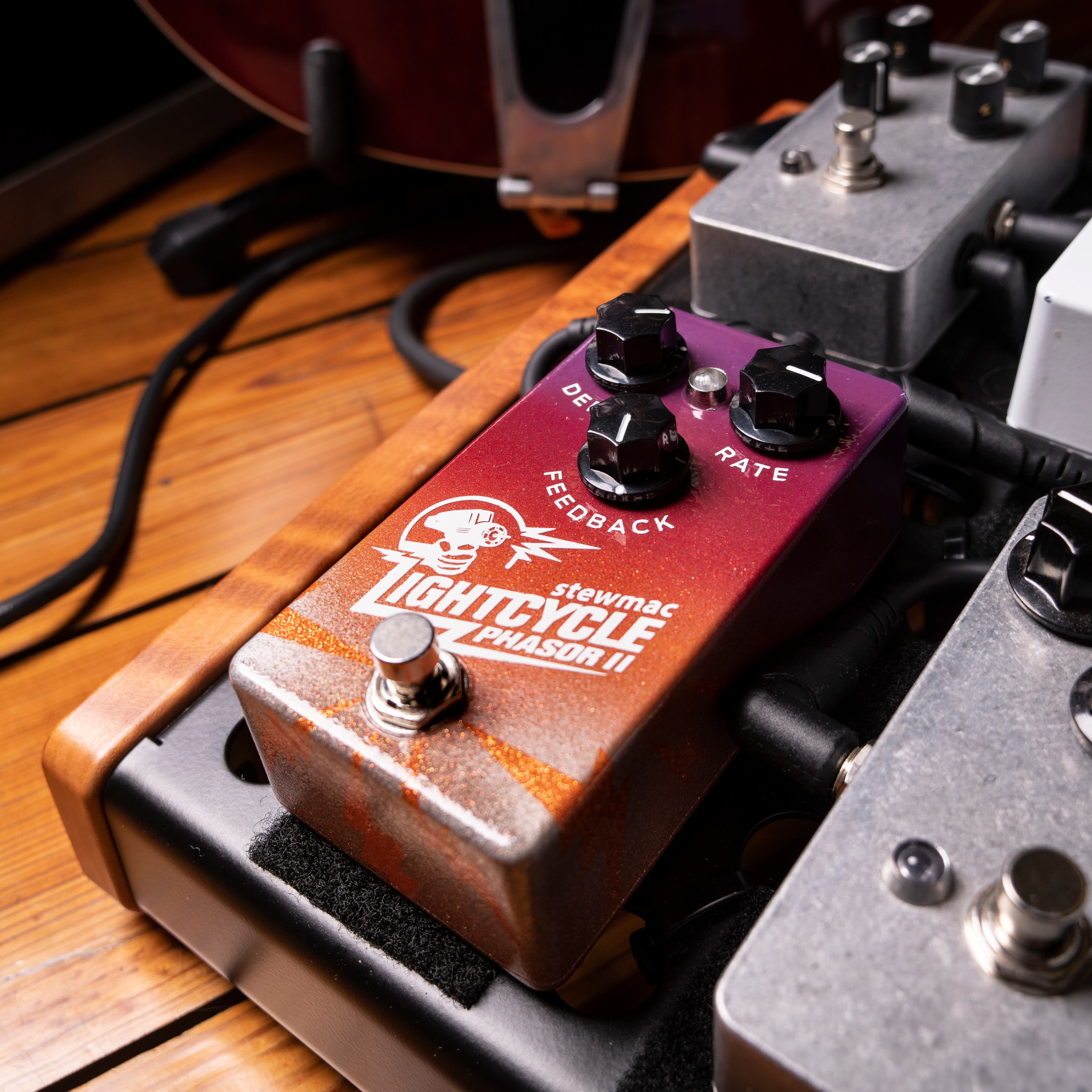 Pedal Phasor II de ciclo de luz en la tabla de pedales con cables de guitarra en el suelo.