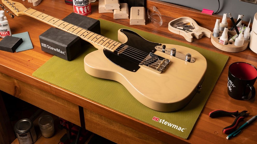 Un banco de trabajo más lujoso con guitarra Fender Telecaster rodeada de herramientas StewMac.