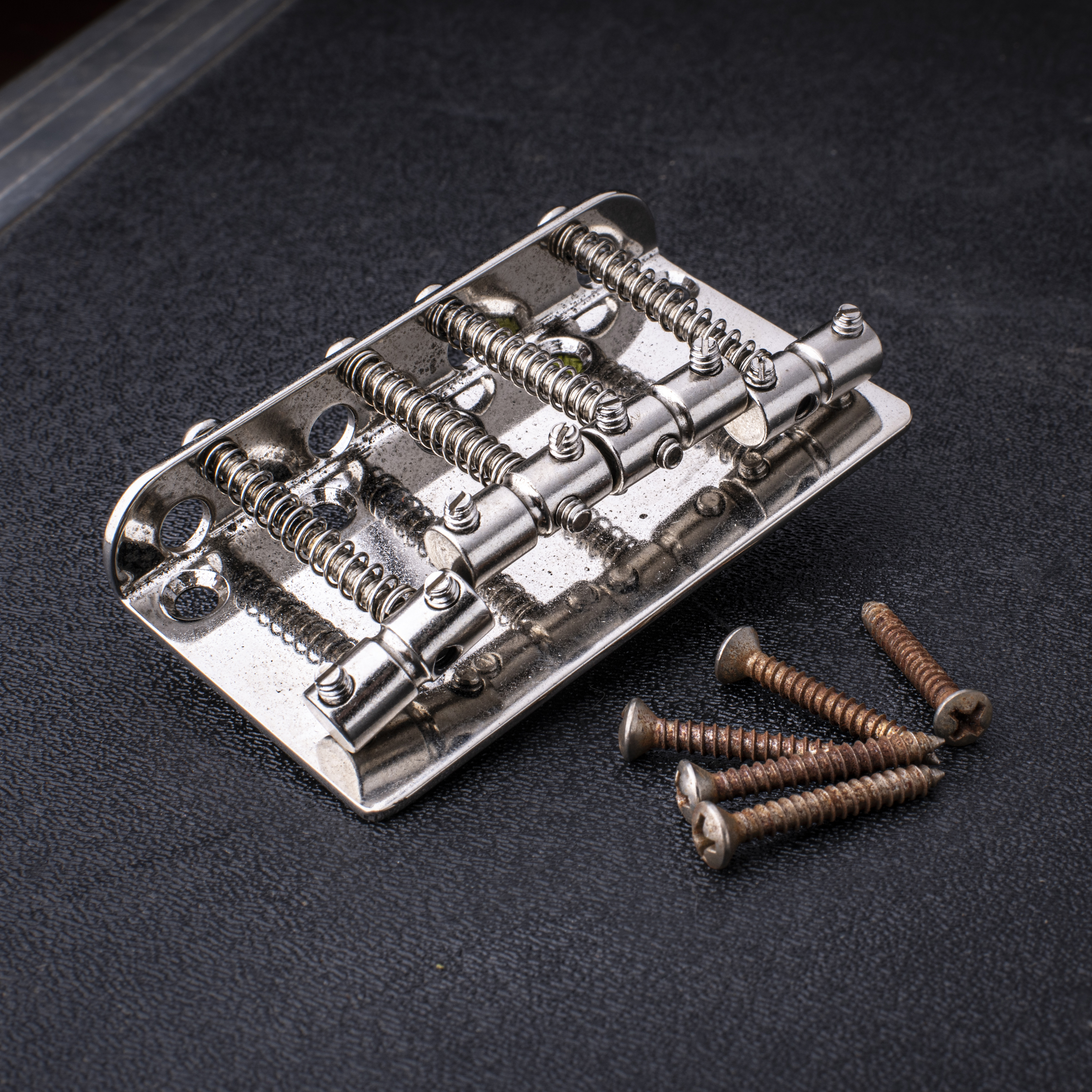 Puente para bajo de 4 cuerdas GuitarSlinger, envejecido y con tratamiento criogénico, con silletas cilíndricas ranuradas