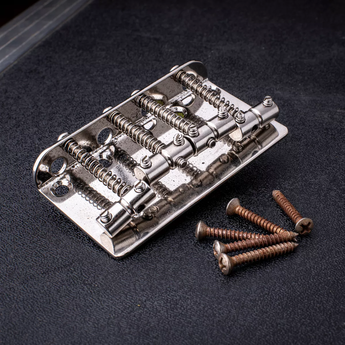 Puente para bajo de 4 cuerdas GuitarSlinger, envejecido y con tratamiento criogénico, con silletas cilíndricas ranuradas Puente para bajo de 4 cuerdas GuitarSlinger, envejecido y con tratamiento criogénico, con silletas cilíndricas ranuradas