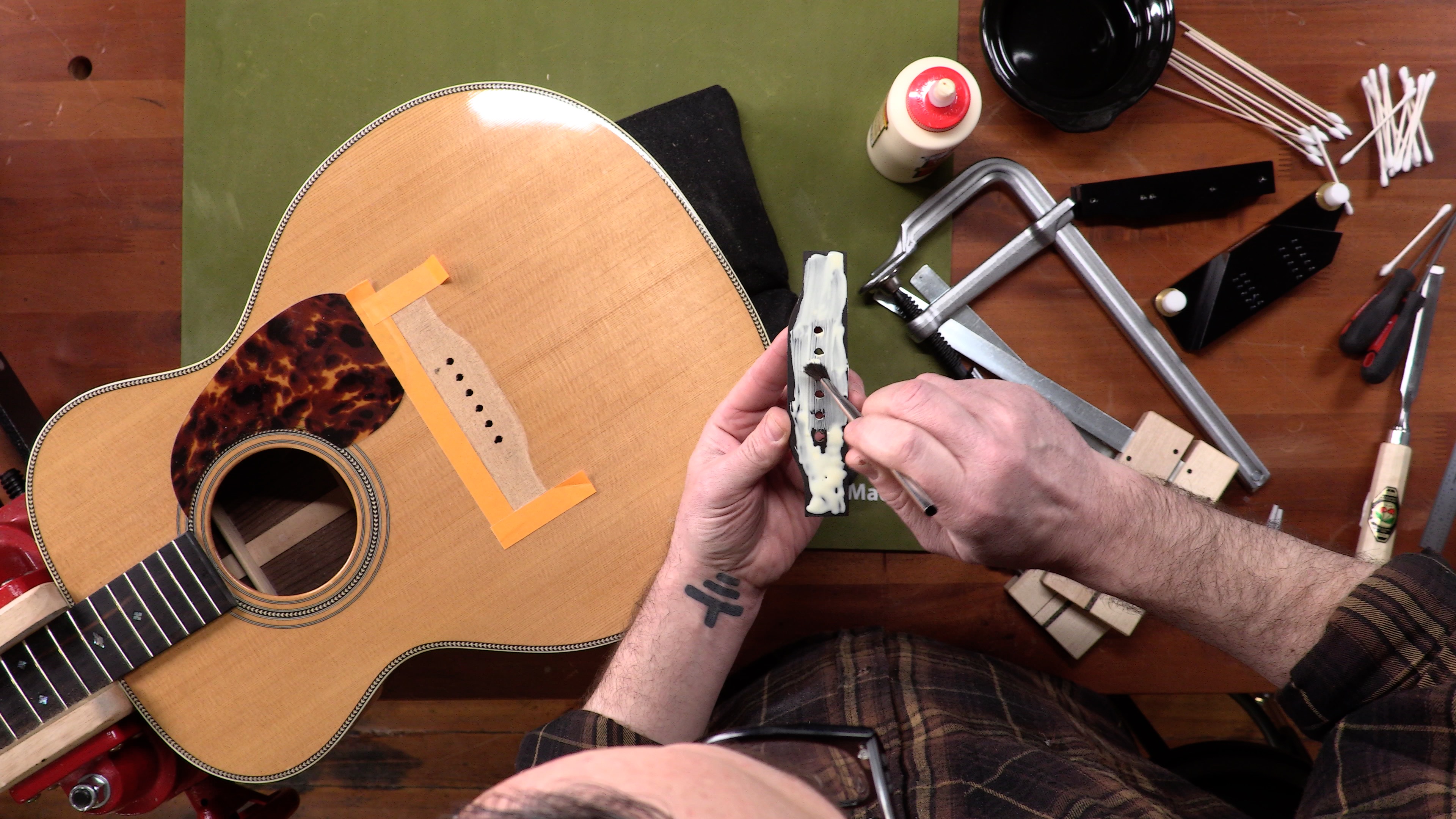 Cómo arreglar un puente de guitarra acústica suelto