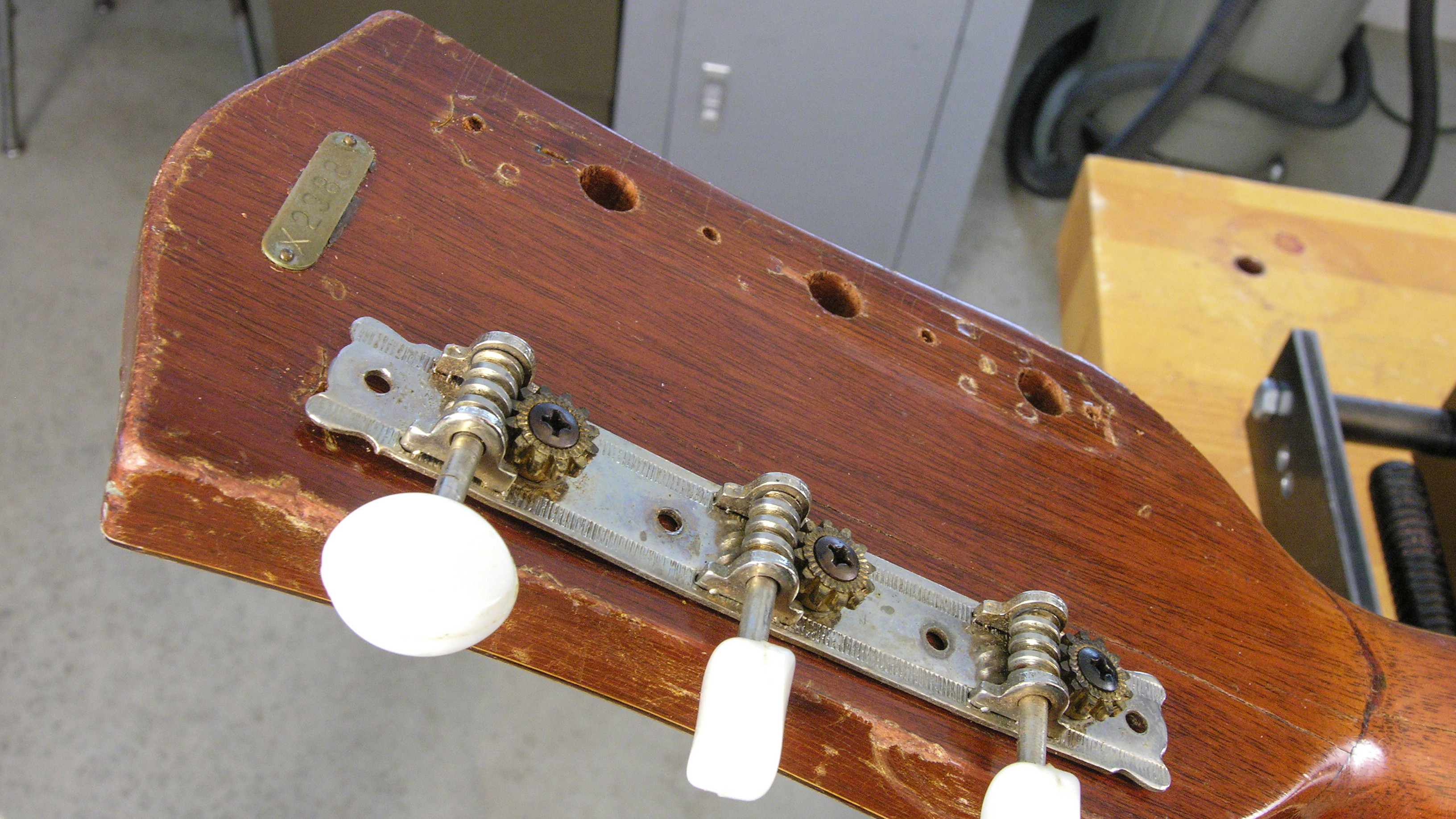 Taponamiento de los orificios del clavijero antiguo en la parte posterior de la pala del pezón