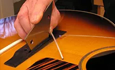 Comprobación de la ranura del silleta con un Fret Rocker