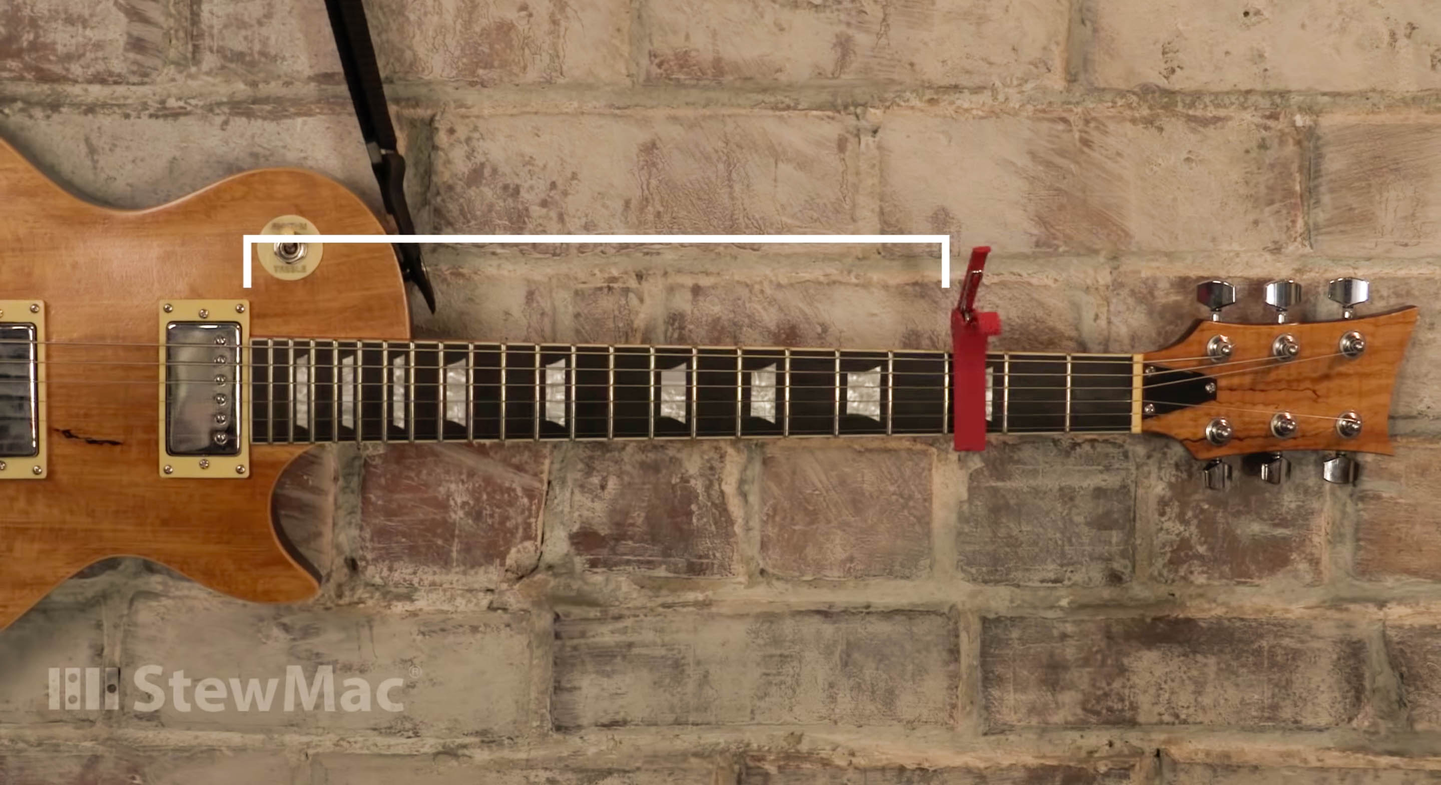 La cejilla se sujeta a las cuerdas del diapasón