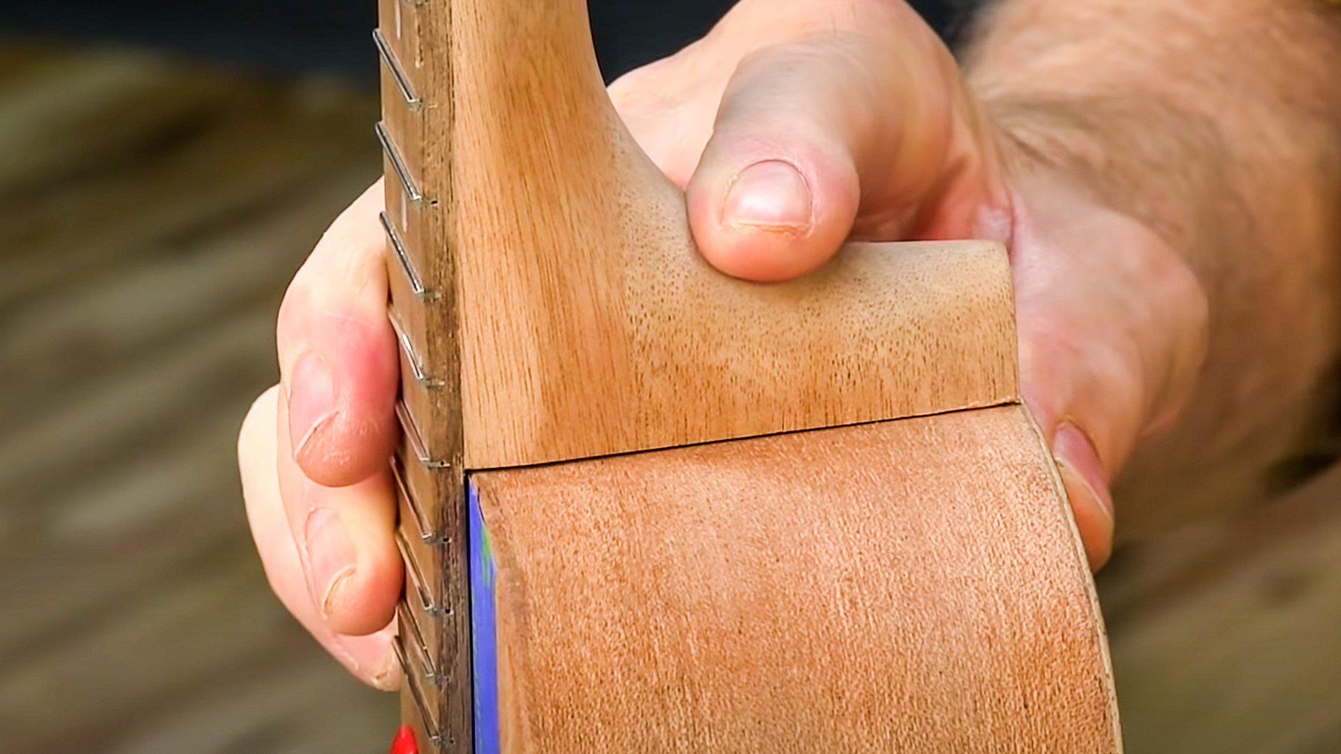 Manos ajustando el mástil de ukulele a cuerpo