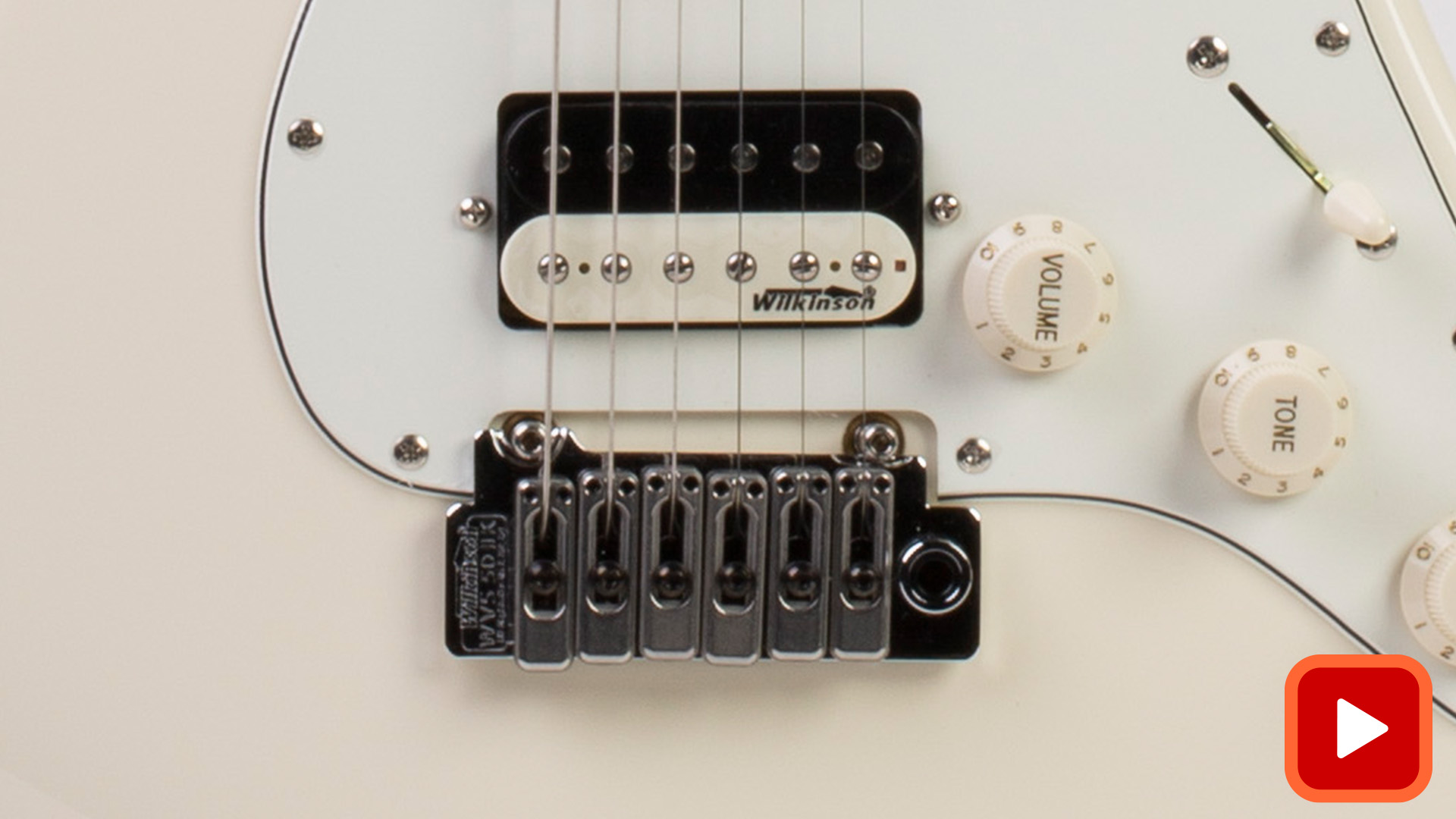 Puente de tremolo de Wilkinson de dos puntos sobre una guitarra blanca